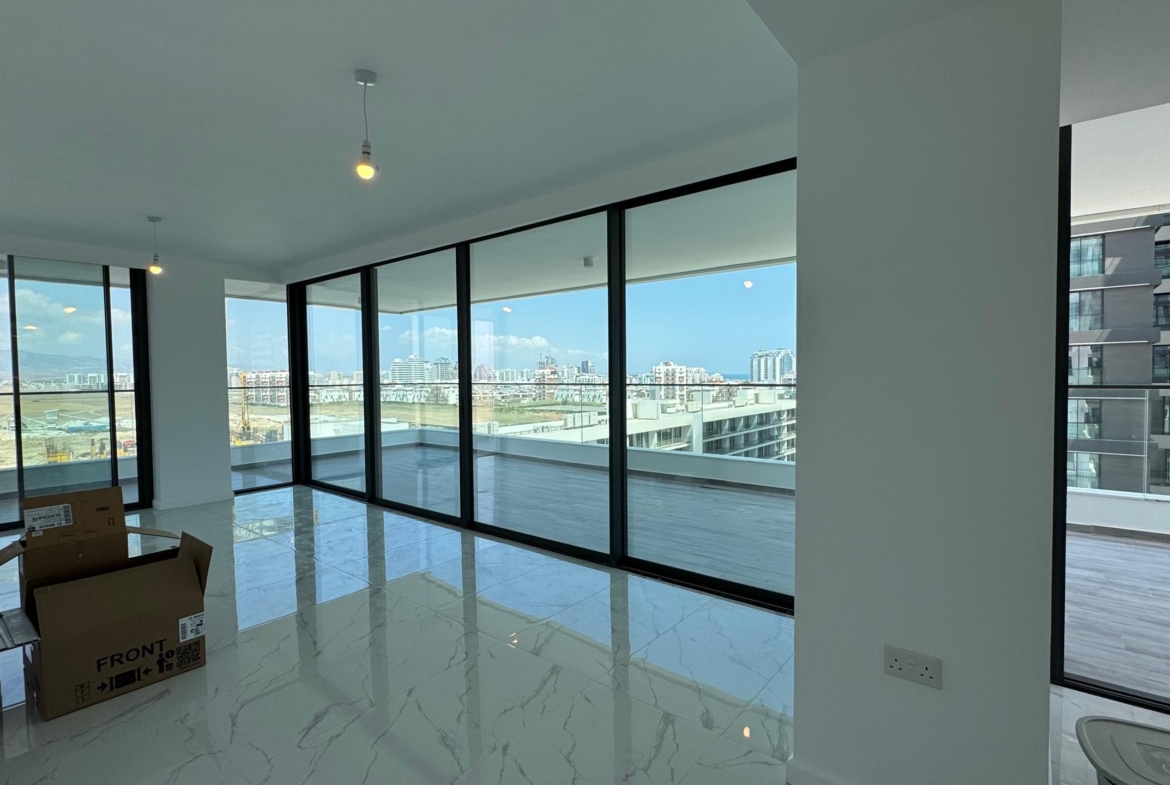 kıbrıs Aysan Giti emlak tarafından listelenen, tavandan tabana geniş pencerelere ve mermer zeminlere sahip modern, mobilyasız bir daire. Kuzey Kıbrıs kiralık daire arayanlar için ideal olan şehir silüeti manzaralı geniş bir balkonun keyfini çıkarın. Yerde bazı taşıma kutuları var. aysan_giti