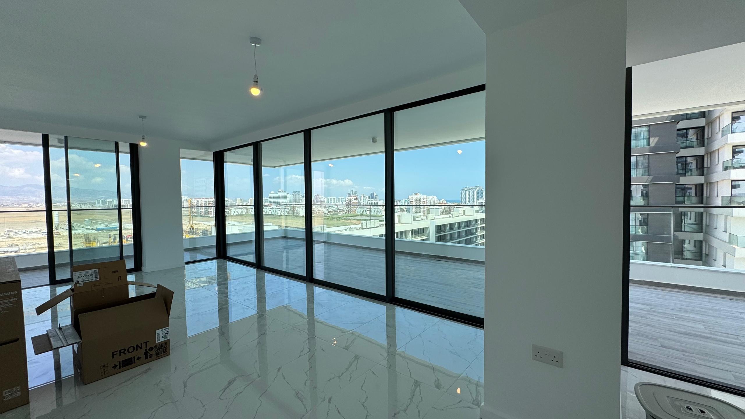 kıbrıs Aysan Giti emlak tarafından listelenen, tavandan tabana geniş pencerelere ve mermer zeminlere sahip modern, mobilyasız bir daire. Kuzey Kıbrıs kiralık daire arayanlar için ideal olan şehir silüeti manzaralı geniş bir balkonun keyfini çıkarın. Yerde bazı taşıma kutuları var. aysan_giti