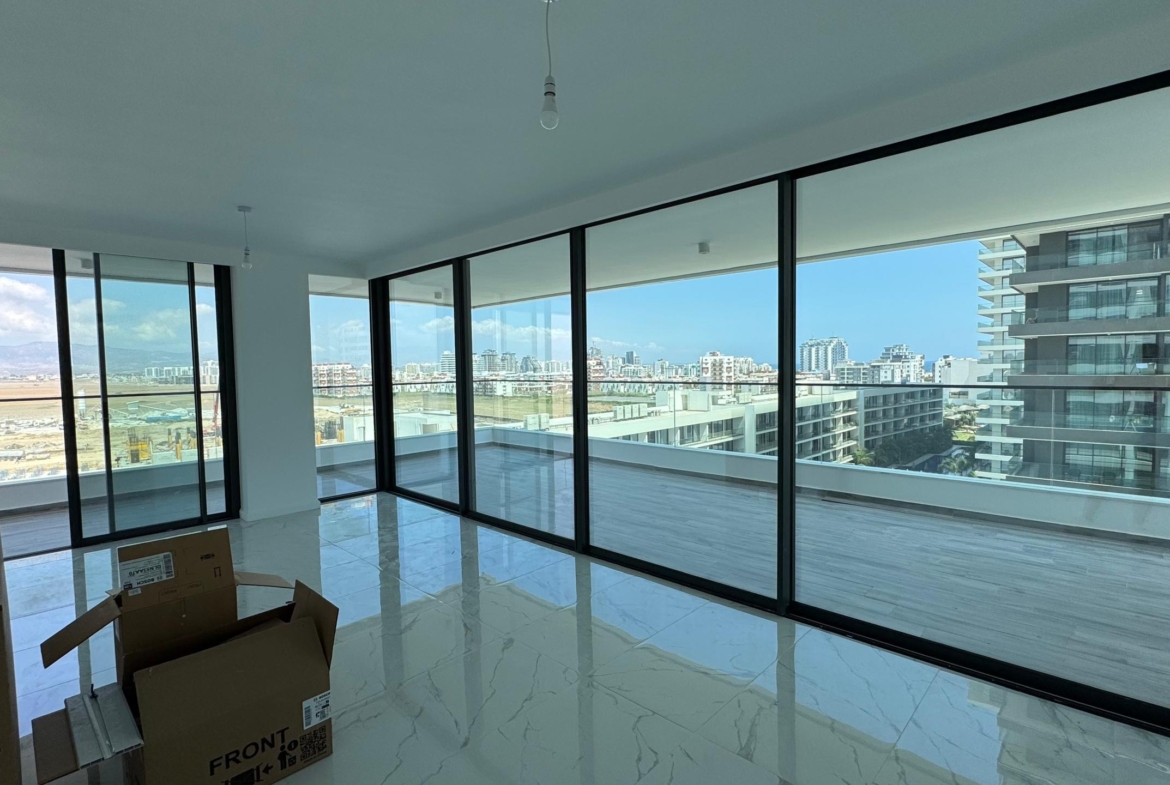 kıbrıs Grand Sapphire Resort & Residence'ta yer alan, tavandan tabana cam pencerelere ve şehir manzaralı geniş bir balkona sahip modern, mobilyasız bir daire. Bu aydınlık, doğal aydınlatmalı alanda 7 yıldızlı otel konseptinde yaşam Kıbrıs'ın keyfini çıkarın. aysan_giti