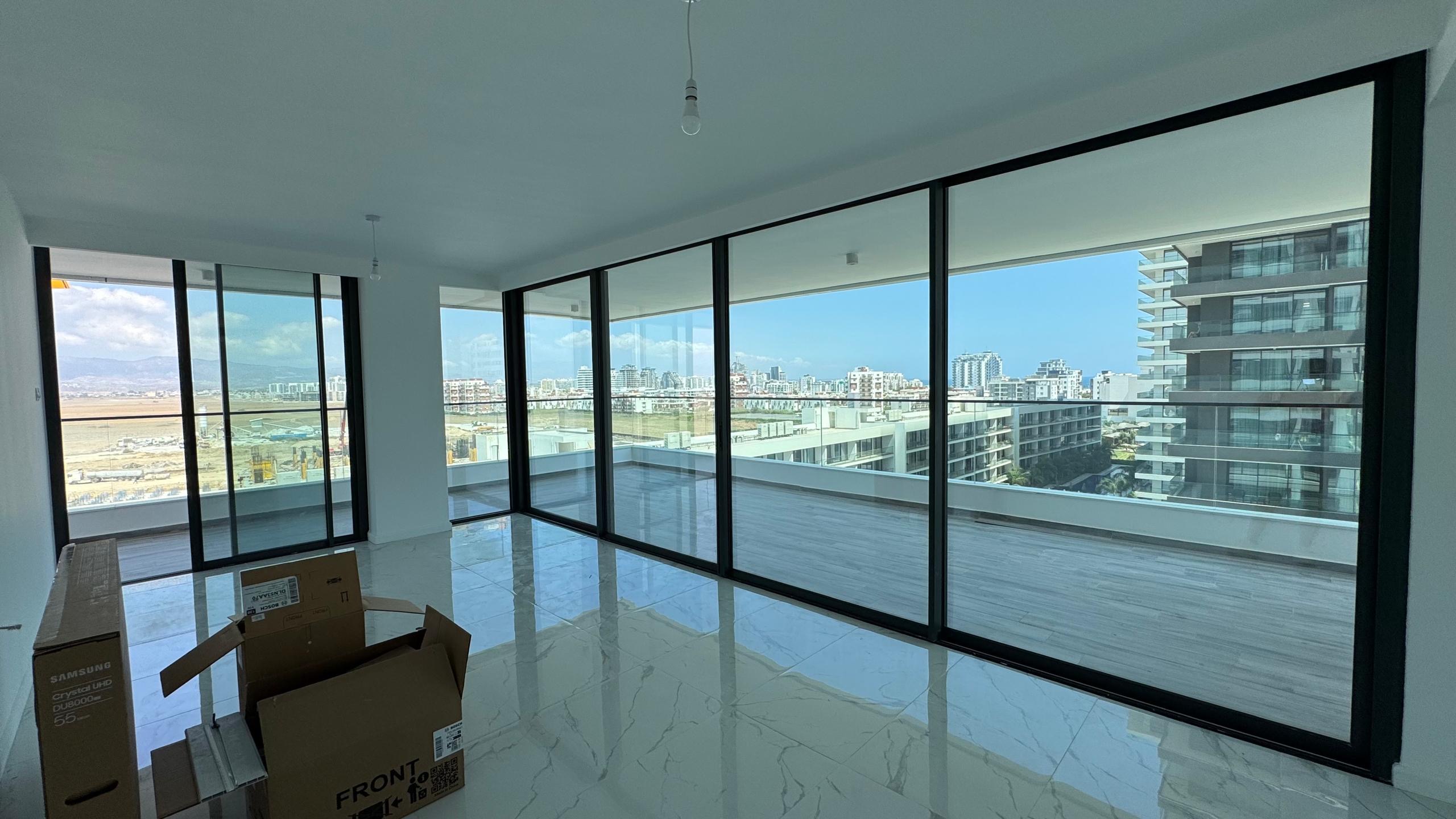 kıbrıs Grand Sapphire Resort & Residence'ta yer alan, tavandan tabana cam pencerelere ve şehir manzaralı geniş bir balkona sahip modern, mobilyasız bir daire. Bu aydınlık, doğal aydınlatmalı alanda 7 yıldızlı otel konseptinde yaşam Kıbrıs'ın keyfini çıkarın. aysan_giti