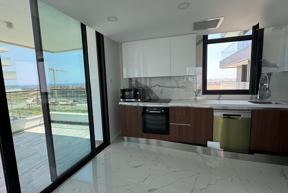 kıbrıs Parlak beyaz ve ahşap dolaplar, ankastre fırın, mikrodalga fırın ve bulaşık makinesi içeren modern mutfak. Grand Sapphire Resort & Residence; 7 yıldızlı otel konseptinde yaşam Kıbrıs'ın balkonundan şehir manzarasının ve bir inşaat vincinin keyfini çıkarın. Mermer tarzı karo zemin. aysan_giti