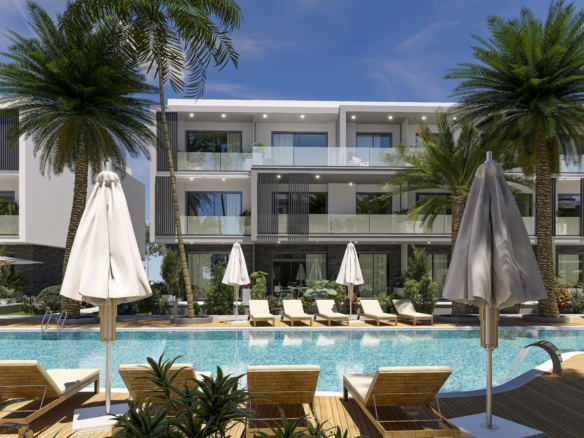 kıbrıs Balkonlu modern apartman, şezlonglar, şemsiyeler ve palmiye ağaçlarıyla çevrili bir havuza bakmaktadır. İskele Long Beach satılık daire arayanlar veya Kuzey Kıbrıs gayrimenkul fırsatlarını keşfetmek için ideal olan bu davetkar ortamda rahatlayın. aysan_giti